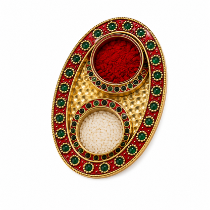 An ornate oval gold-toned tray with two circular compartments filled with red and white powders, surrounded by red enamel and green stone accents, photographed on a plain white background.